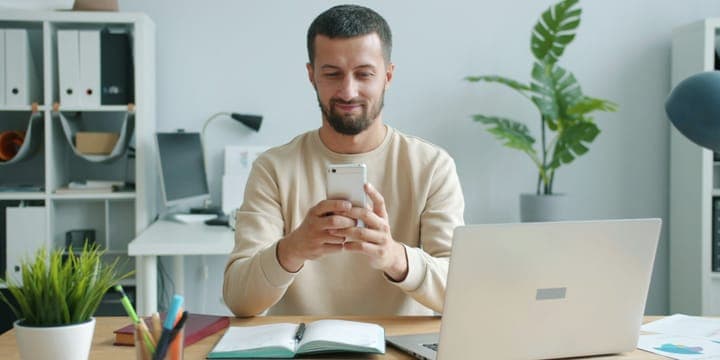 Osoba patrząca w telefon przy pracy